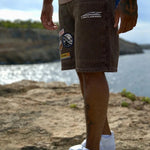 Last Lesson badged Casazøna shorts with patches worn by a person outdoors near water