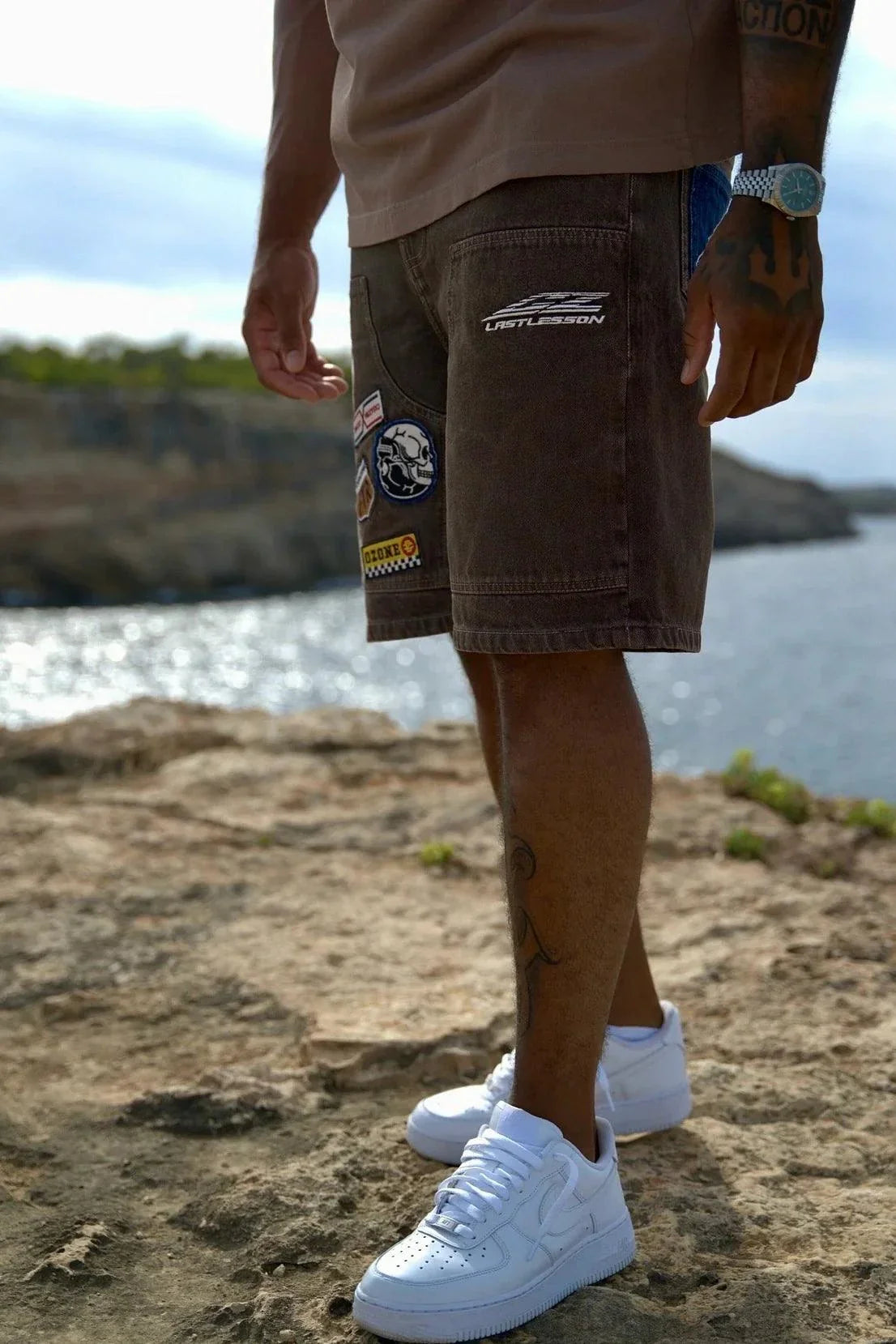 Last Lesson badged Casazøna shorts with patches worn by a person outdoors near water