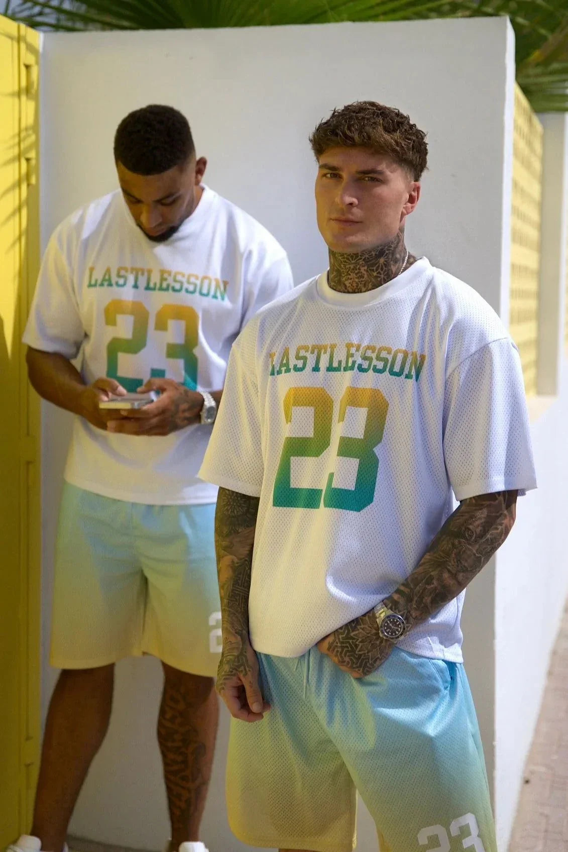Men wearing Last Lesson gradient jerseys with number 23 in casual outdoor setting
