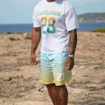 Man wearing Last Lesson Gradient Jersey t-shirt and shorts with gradient colors on beach background