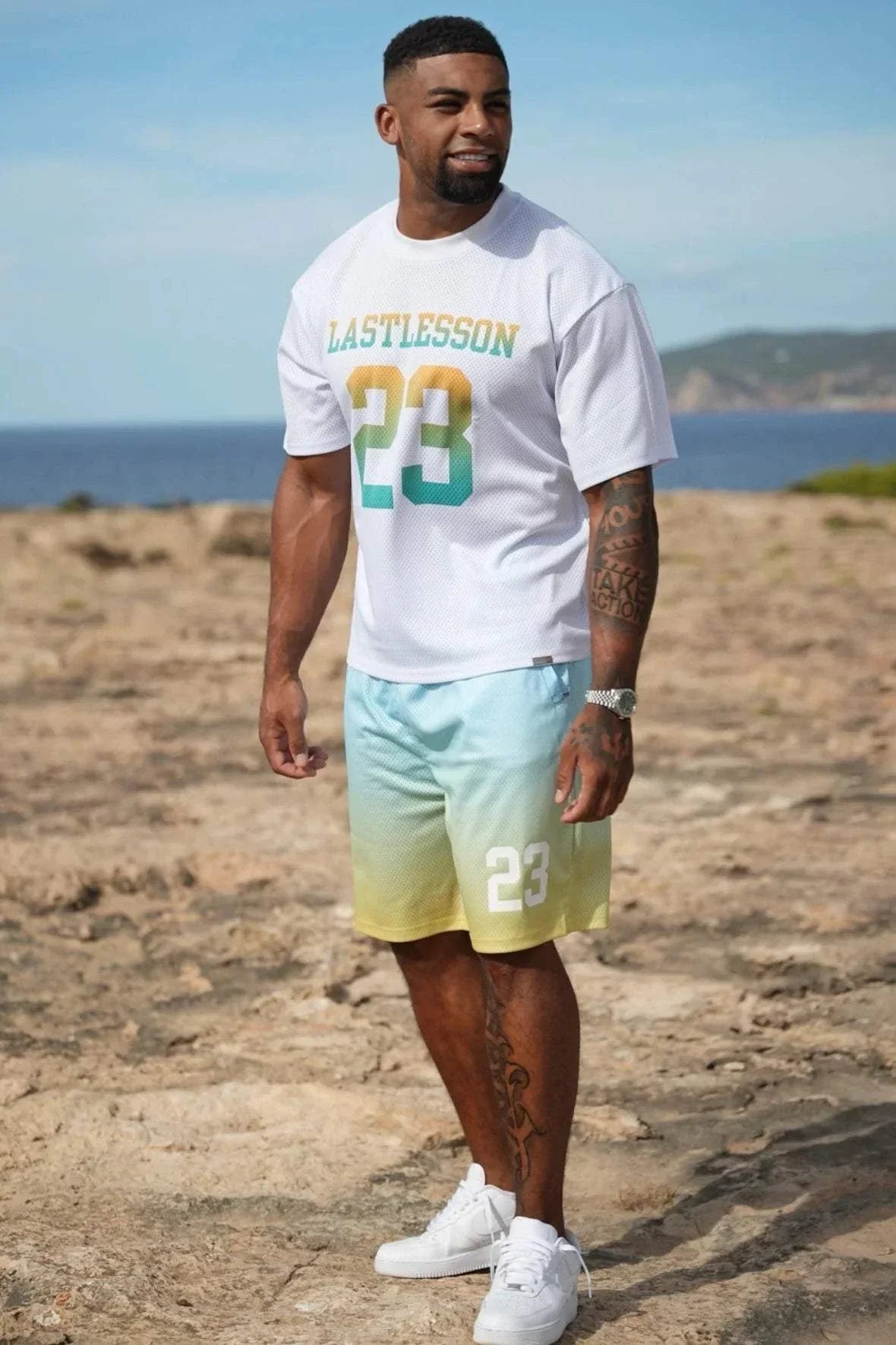 Man wearing Last Lesson Gradient Jersey t-shirt and shorts with gradient colors on beach background
