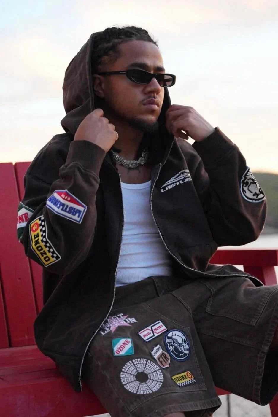 Man wearing Last Lesson Badged Casazøna Hoodie with patches and sunglasses outdoors