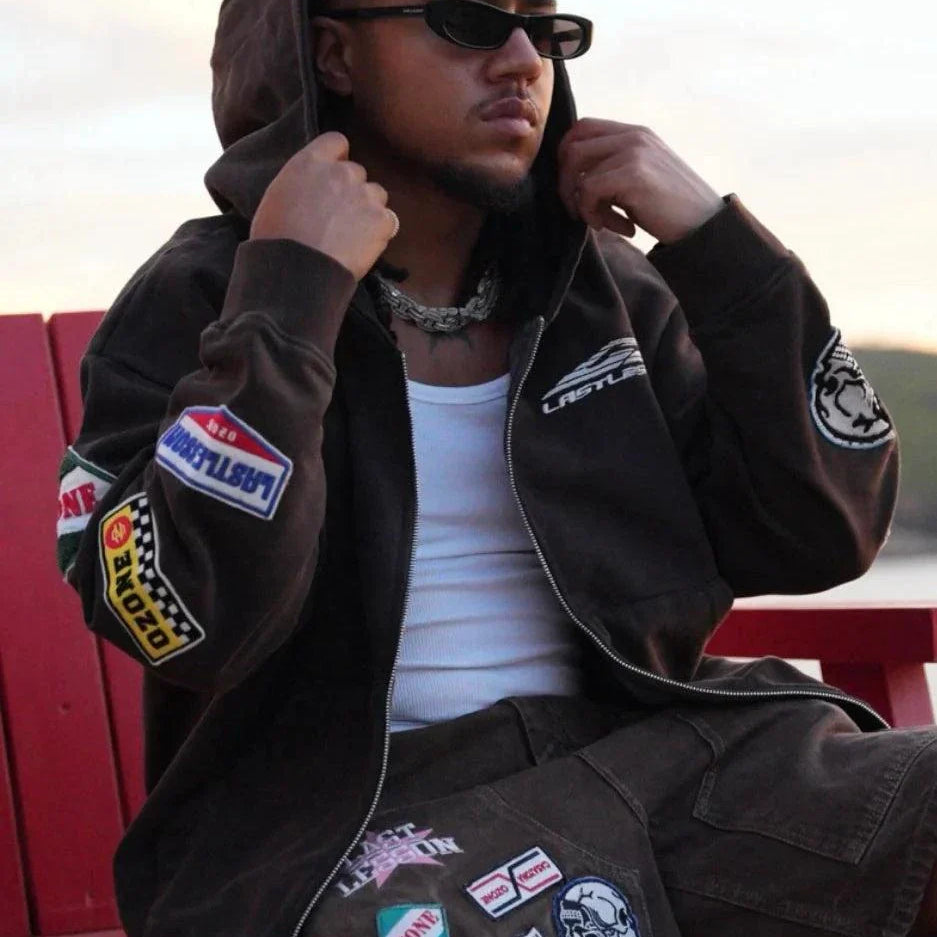 Man wearing Last Lesson Badged Casazøna Hoodie with patches and sunglasses outdoors