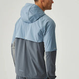 Man wearing dusky blue and turbulence Reprimo Vortex Windbreaker with ergonomic panels and reflective detailing viewed from the back