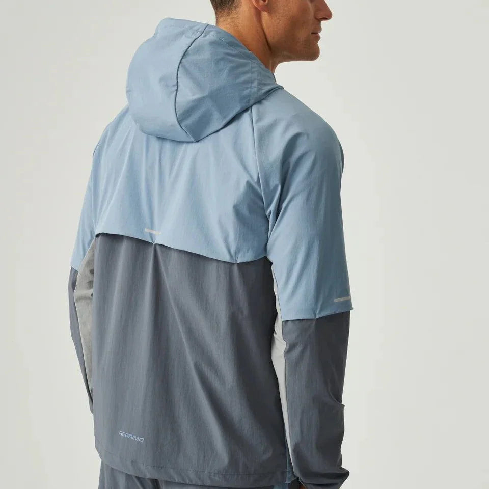 Man wearing dusky blue and turbulence Reprimo Vortex Windbreaker with ergonomic panels and reflective detailing viewed from the back