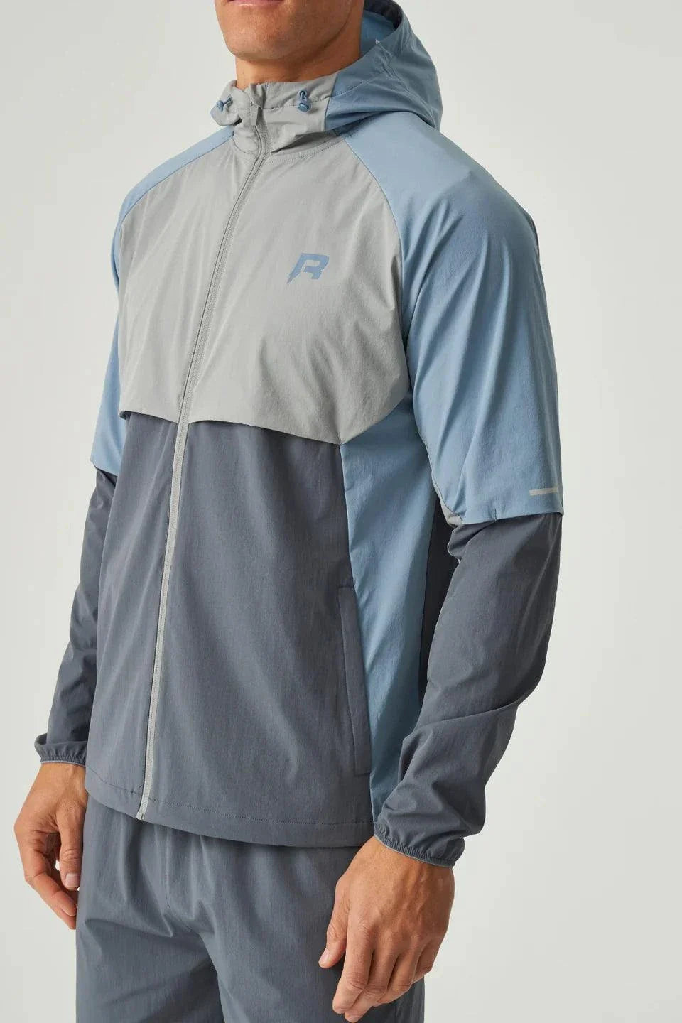 Reprimo Vortex Windbreaker in dusky blue with ergonomic panels and reflective details, lightweight and wind-resistant jacket.