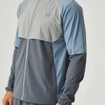 Reprimo Vortex Windbreaker in dusky blue with ergonomic panels and reflective details, lightweight and wind-resistant jacket.