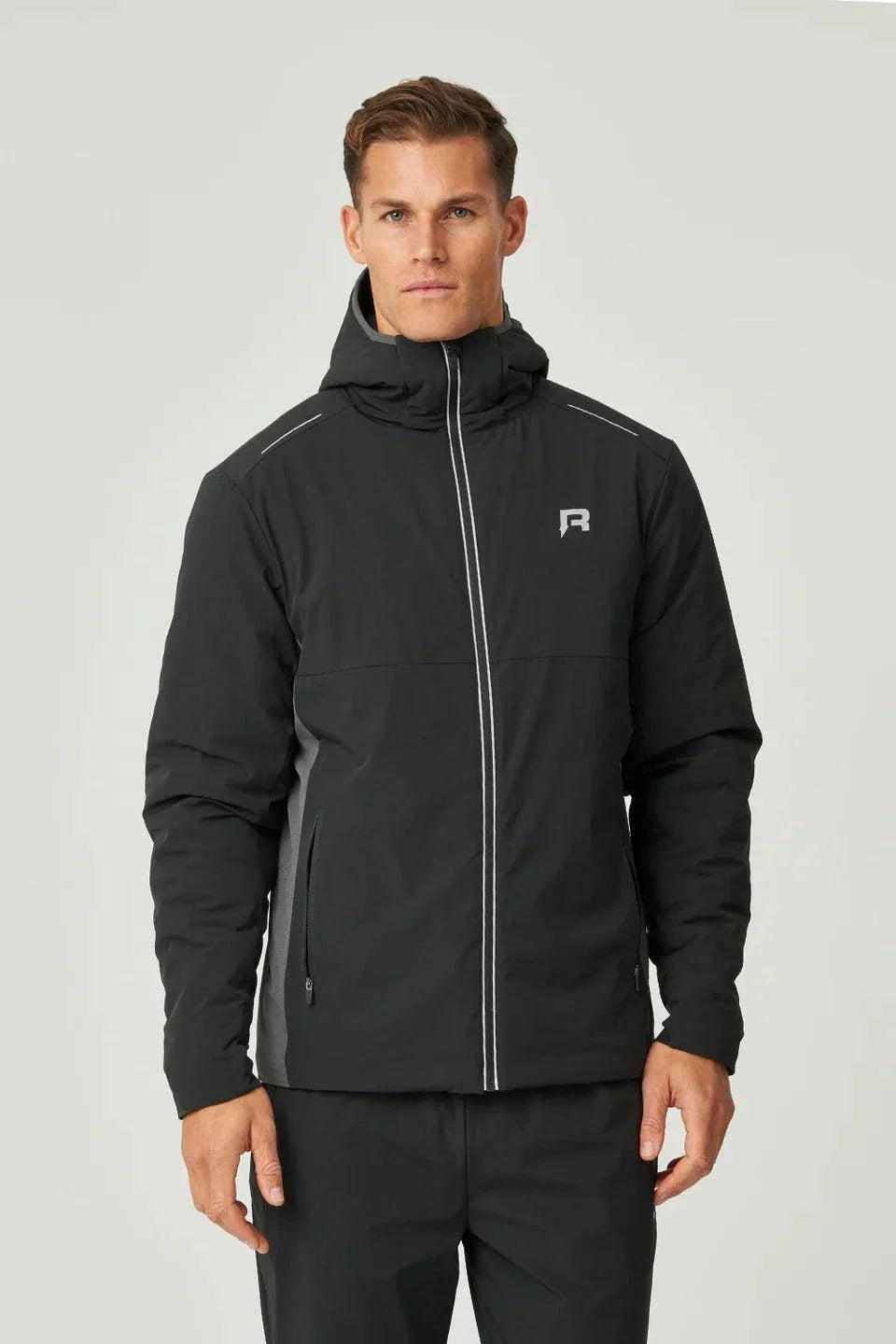Man wearing black Reprimo Clima Jacket with zip pockets and hood, lightweight windbreaker for outdoor activities