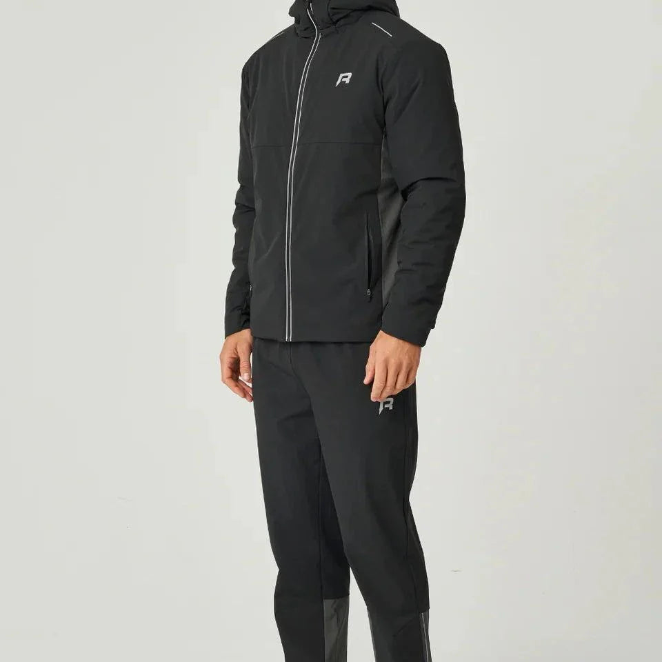 Man wearing black Reprimo Clima Jacket with zip pockets and hood, paired with matching pants