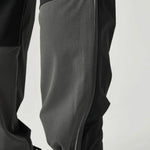 Close-up of Reprimo Clima Pants in black and charcoal showing breathable calf fabric and adjustable ankle cuffs for active performance.