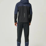 Rear view of man wearing black and navy Reprimo Nova Jacket with hood and reflective detailing