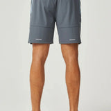 Back view of dusky blue Reprimo Vortex Shorts with adjustable waistband and ergonomic panel detailing worn by male model