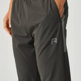 Close-up of olive and dark grey Reprimo Vortex Pants with ergonomic paneling and adjustable waistband for active wear
