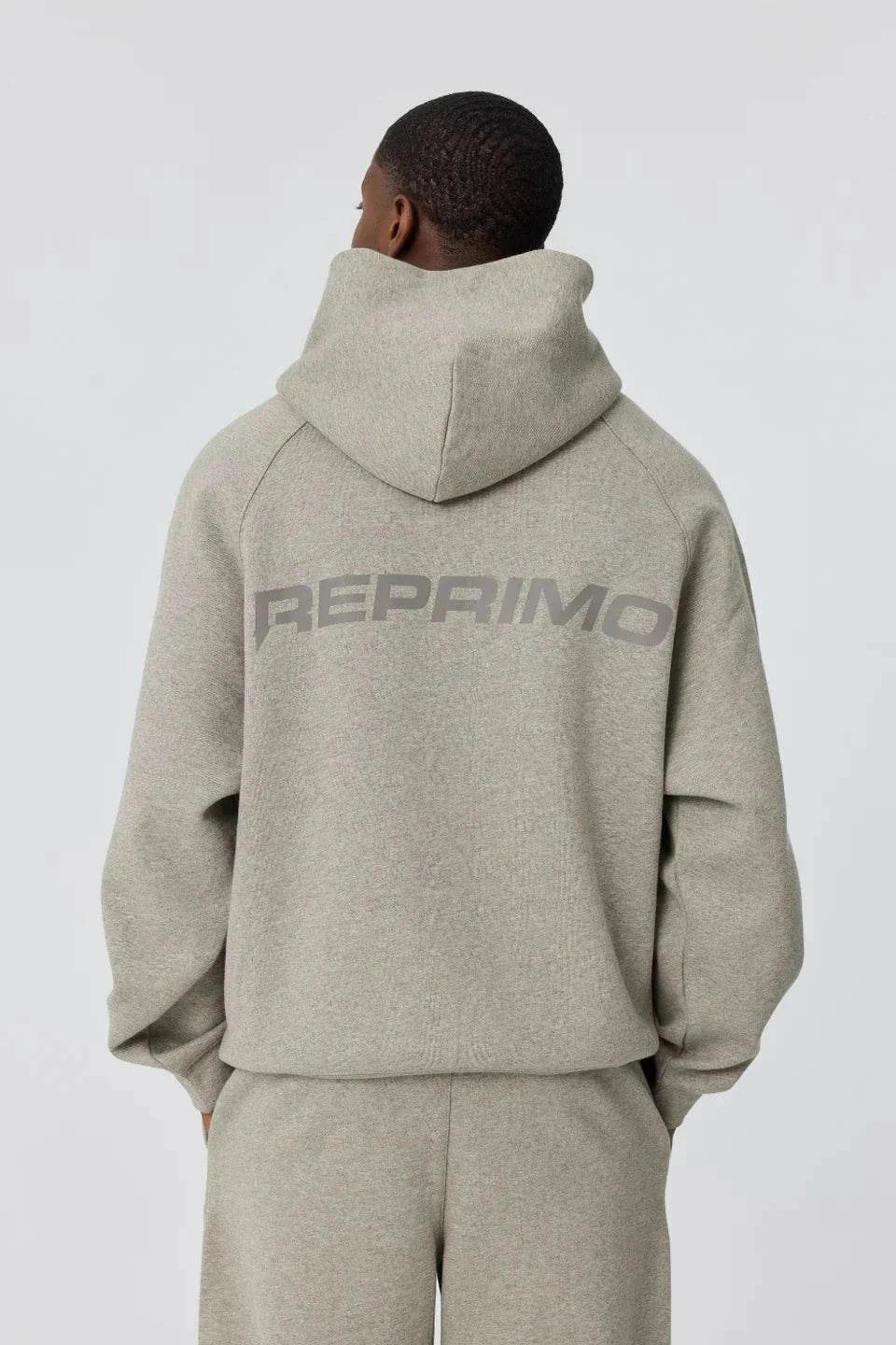 Back view of grey Reprimo Collective Hoodie with reflective branding on brushed-back jersey fabric
