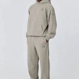 Man wearing grey Reprimo Collective Hoodie and matching sweatpants in athletic style