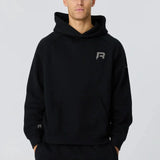 Man wearing black Reprimo Collective Hoodie with reflective logo, soft brushed-back fabric, and ergonomic fit