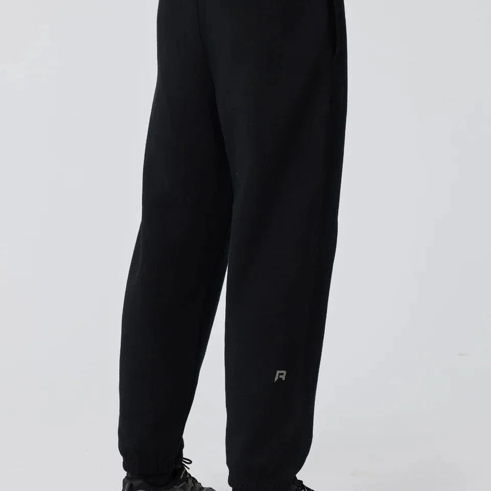 Black Reprimo Collective Joggers with brushed-back jersey fabric, ergonomic fit, adjustable waistband, and reflective branding details.