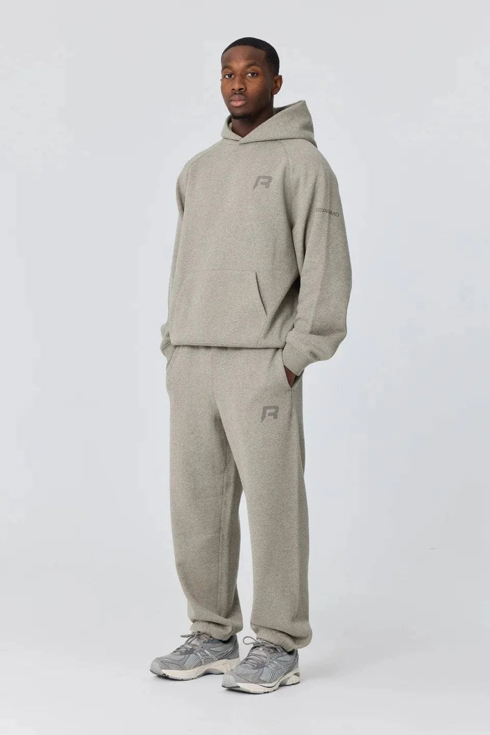 Man wearing grey Reprimo Collective Joggers with matching hoodie and sneakers