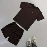 Studio Pocket Tee by Charles Brown Studio hanging on wooden hangers against white background