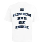 White t-shirt with navy text "The Wildest Dreams Have to Start Somewhere" on the back