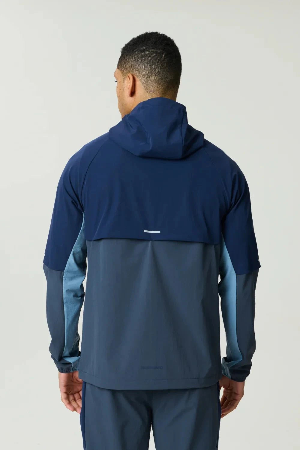 Reprimo Vortex Windbreaker in dusty blue and ink blue with ergonomic panels and reflective details
