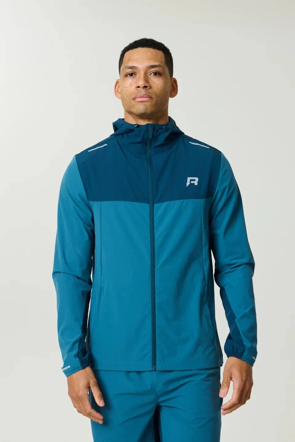 Reprimo Flight Windbreaker in lake blue and teal with zip pockets and back vent for lightweight weather protection