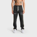 Front view of a person wearing black ANNIE HOOD track pants with white side stripes and drawstring waist