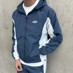 Siarr Orbit Windbreaker Marine Blue with silicone logo patch, drawcords, and side pockets.