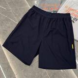 Navy studio shorts by Studio By Charles on marble floor.