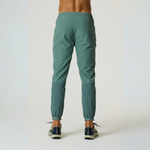Back view of man wearing Reprimo Glide Pants in botanical pine with elasticated cuffs and tapered fit