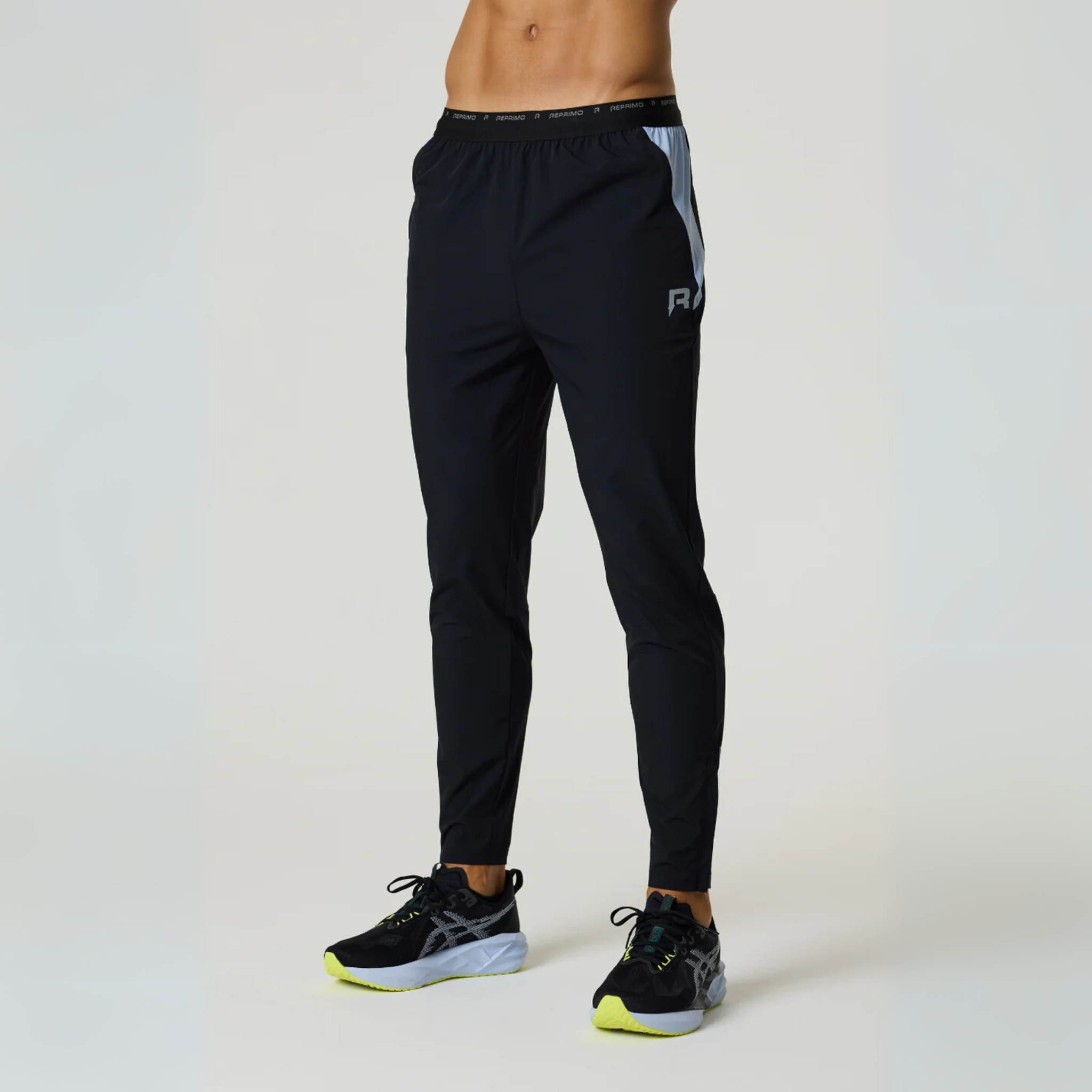 Black Reprimo Flight Pants with functional side pockets and reflective strips for enhanced visibility and comfort during workouts