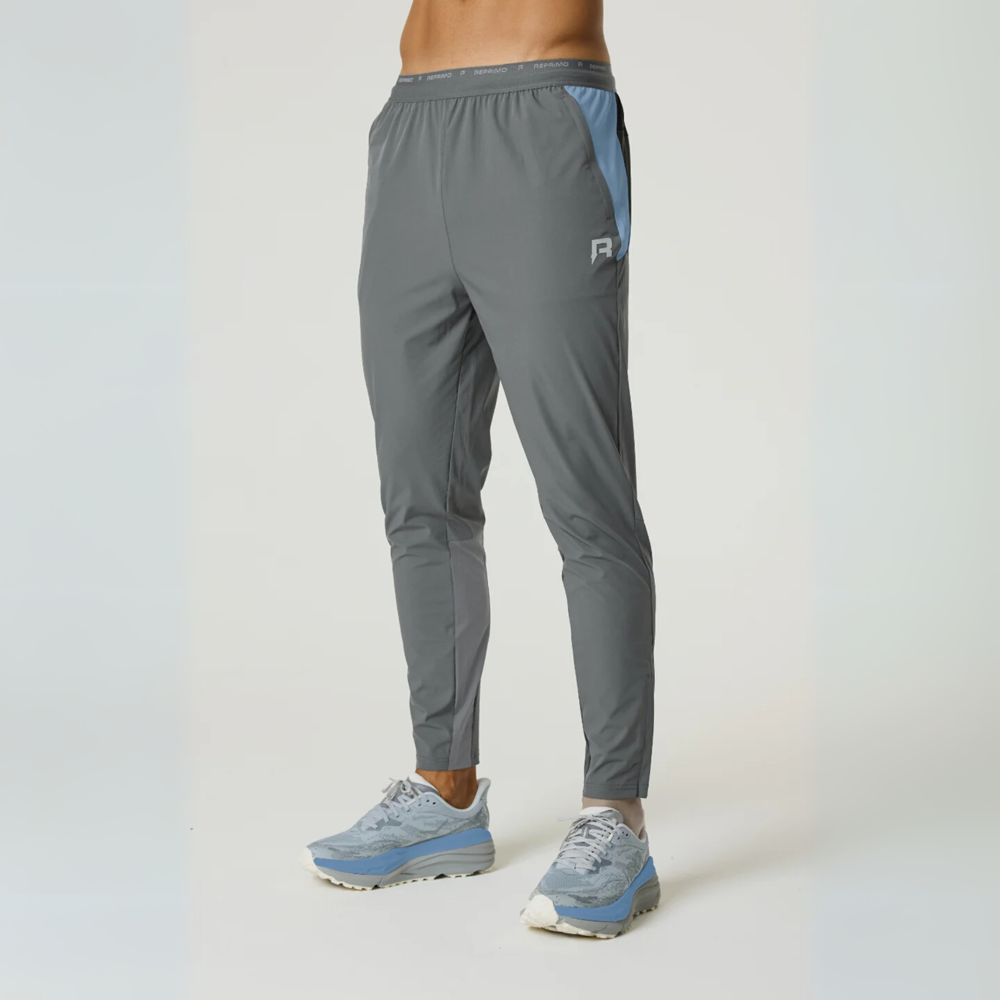 Reprimo Flight Pants in air force blue and gunmetal with side pockets and reflective strips for athletic performance and comfort