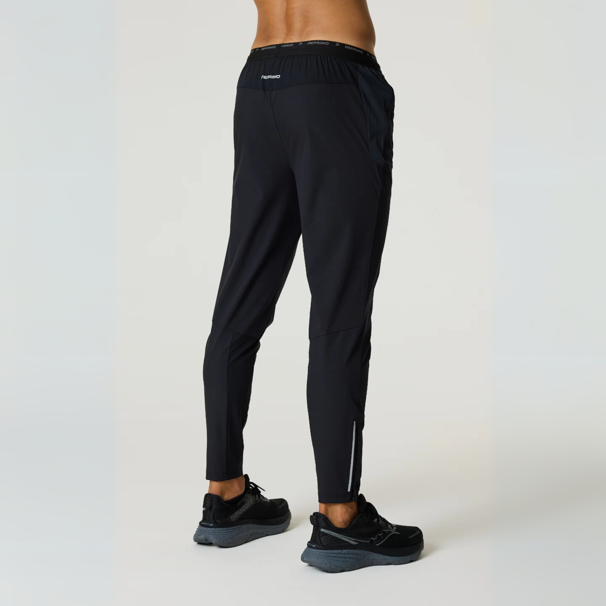 Black Reprimo Flight Pants with reflective strips and functional side pockets designed for athletic performance and comfort.