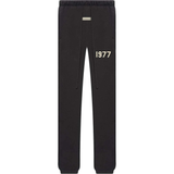 Fear of God Essentials black sweatpants with elastic cuffs and 1977 print