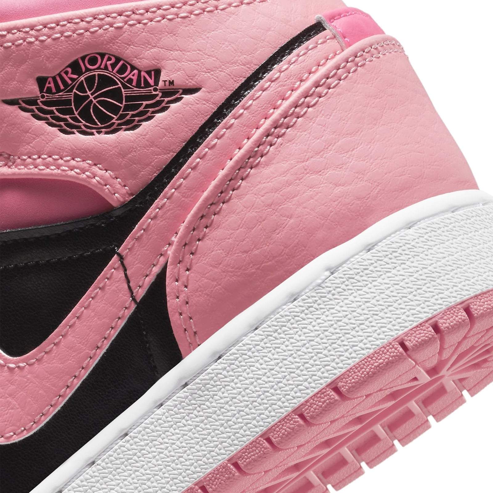 Air Jordan 1 Mid Coral Chalk GS sneaker detail featuring pink, black, and white colorway with Air Jordan wings logo.