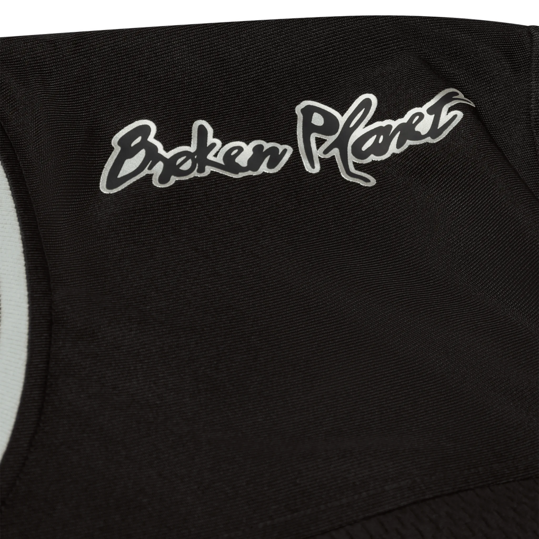 Black and silver Broken Planet Market football jersey close-up.