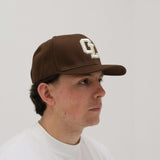 Cherry Location CL Brown Cap on textured background