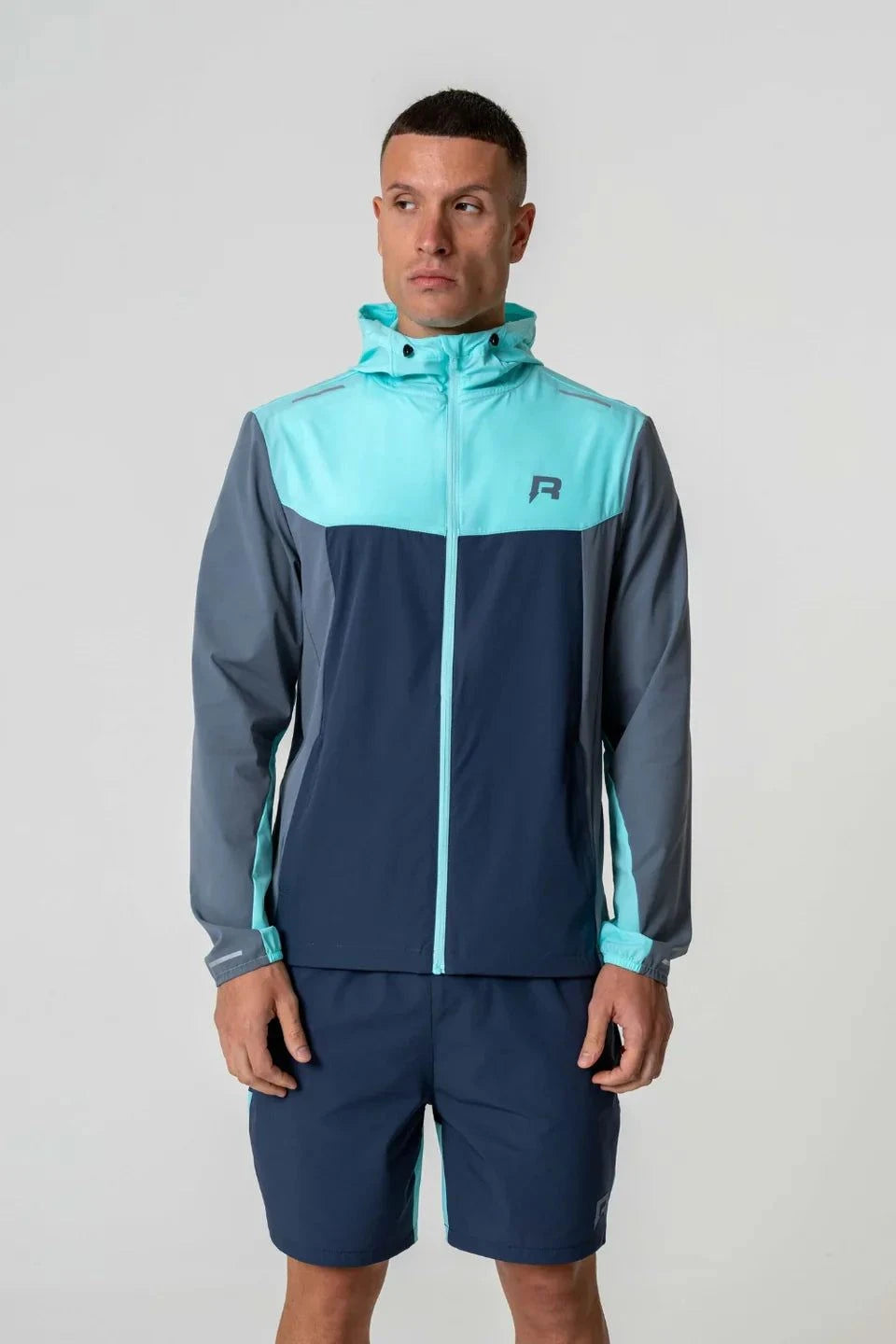 Reprimo Flight Windbreaker in cyan and navy with hood.