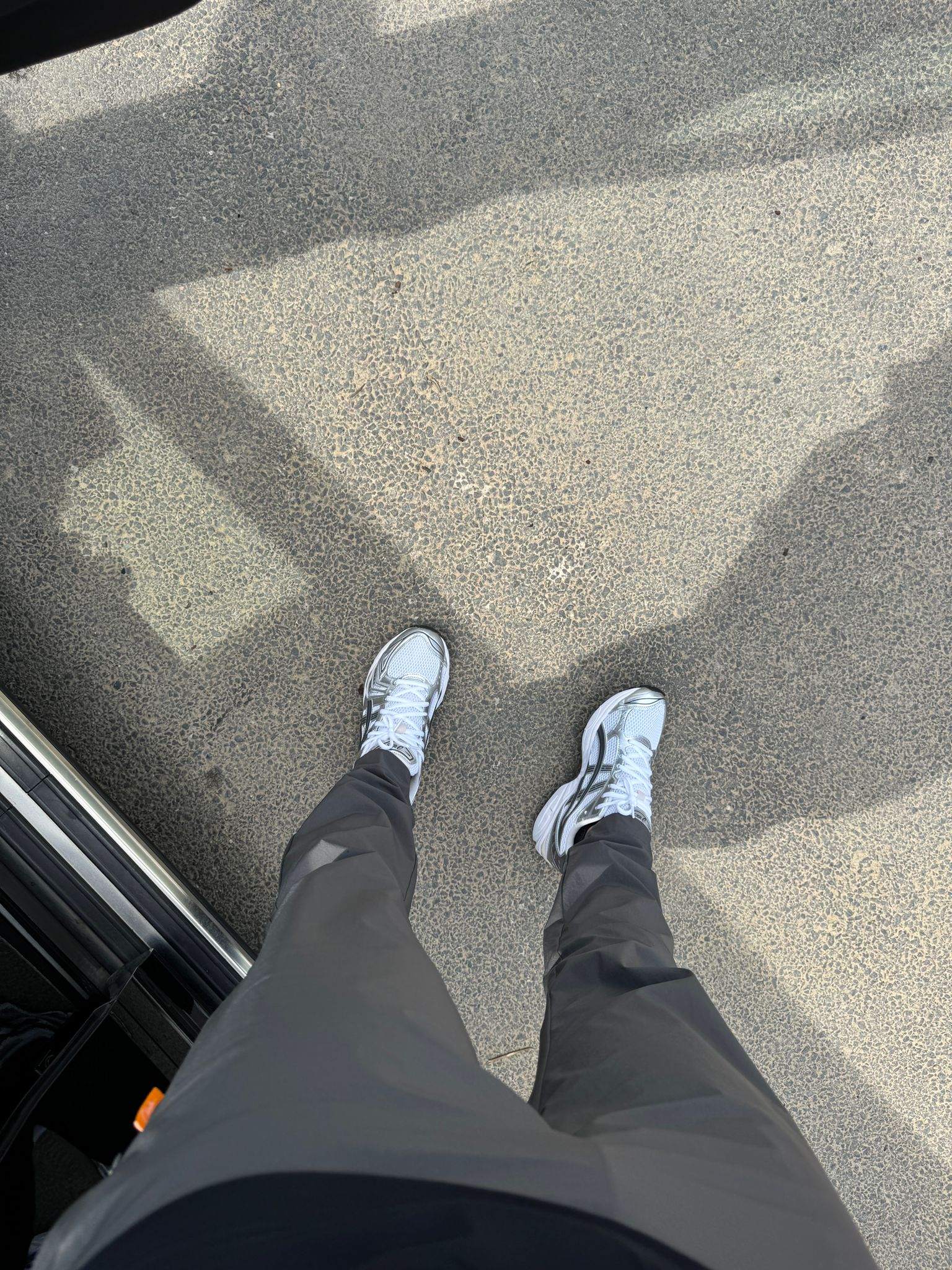Studio By Charles charcoal grey trackpants worn with white sneakers on pavement background