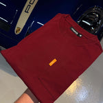 Studio By Charles burgundy long sleeve tee folded on blue Porsche car hood