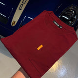 Studio By Charles burgundy long sleeve tee folded on blue Porsche car hood