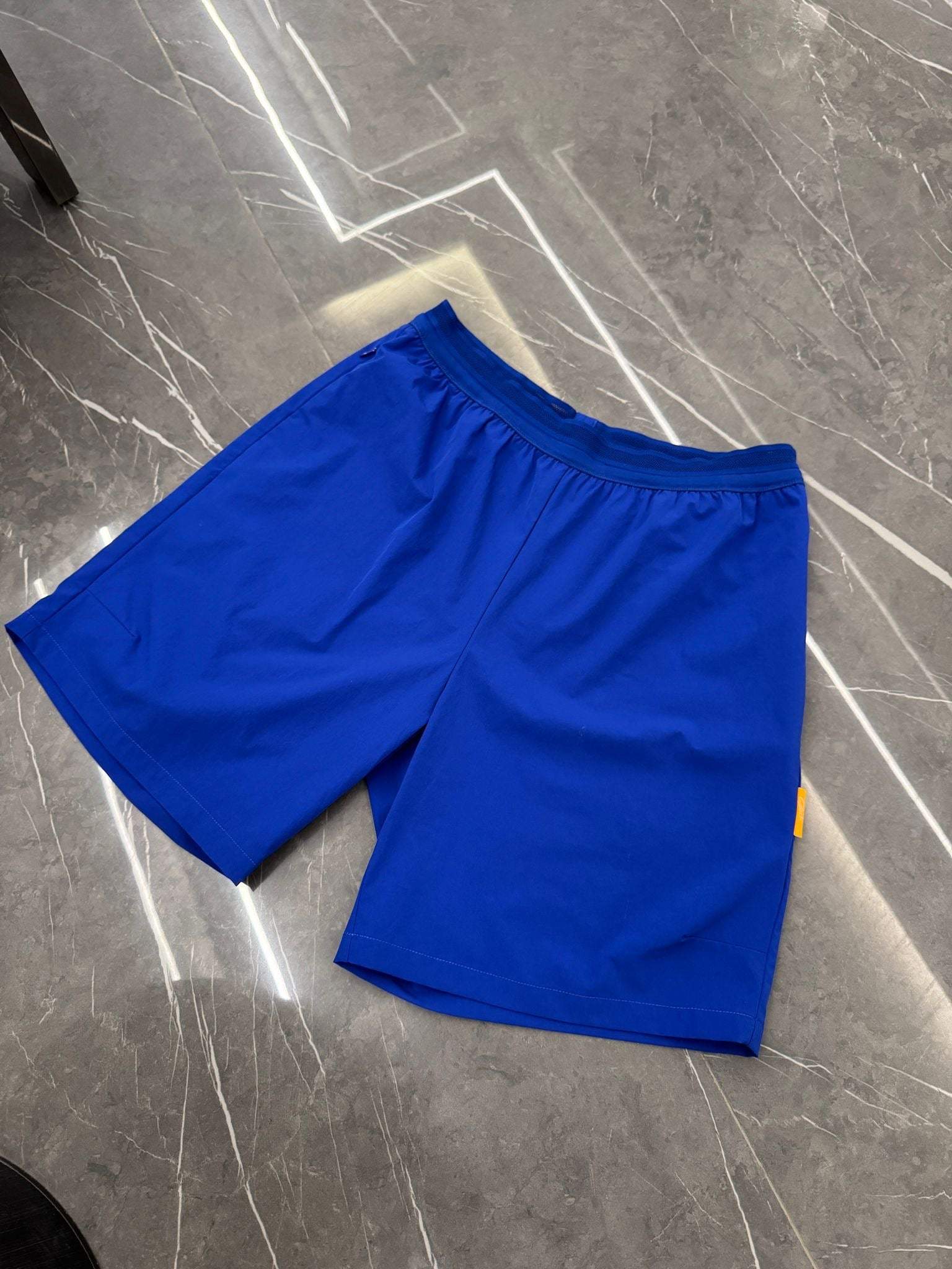Studio By Charles royal blue studio shorts with elastic waistband on gray marble floor
