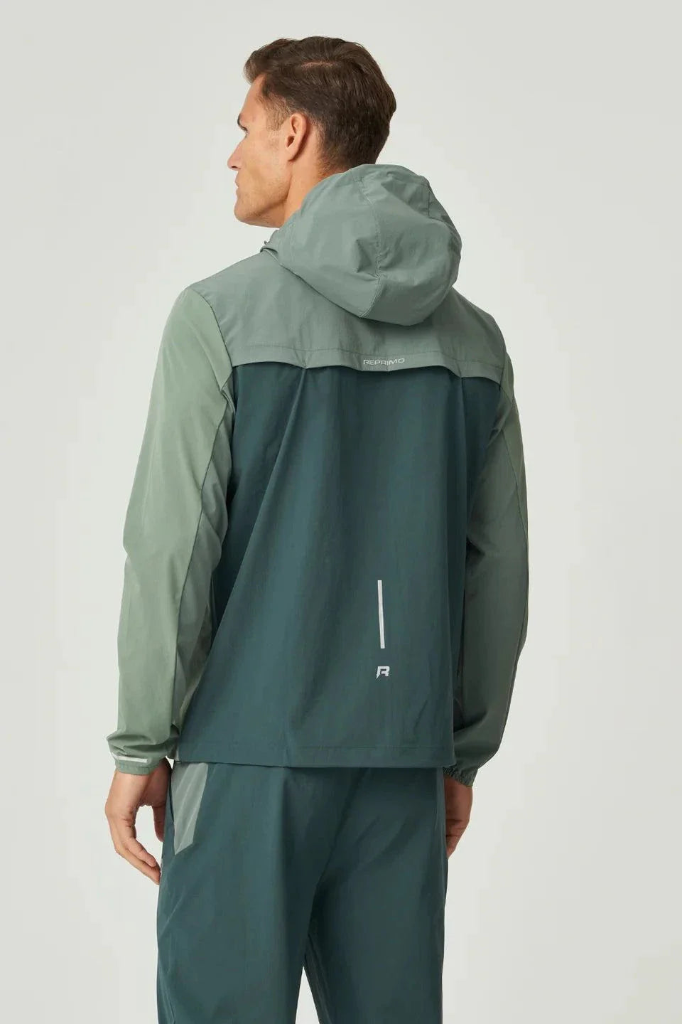 Reprimo Flight Windbreaker in hunter green and botanical colors with hood, zip pockets, and back vent for ventilation, designed for lightweight weather protection.