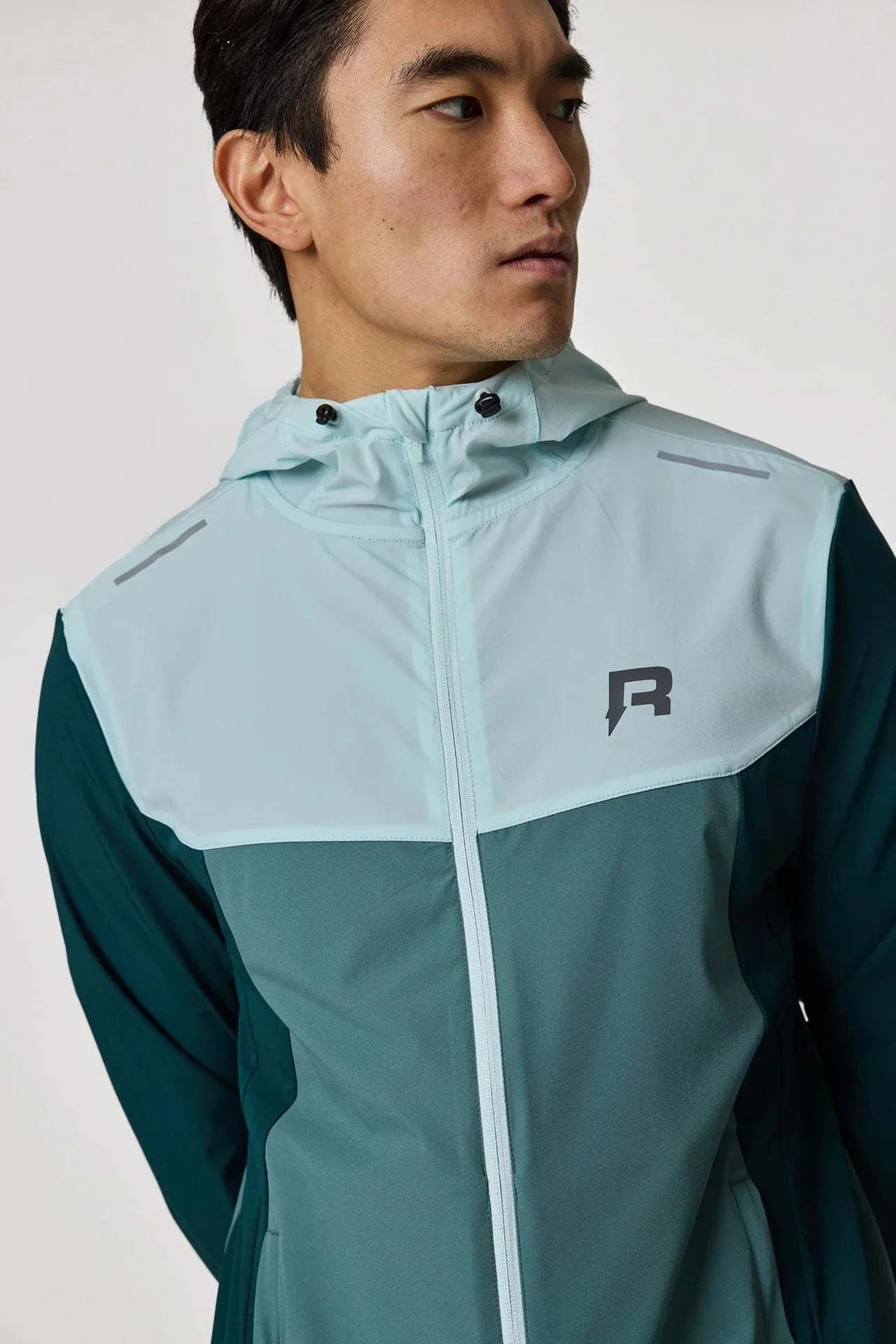 Reprimo Flight Windbreaker in forest green and mint worn by a model.