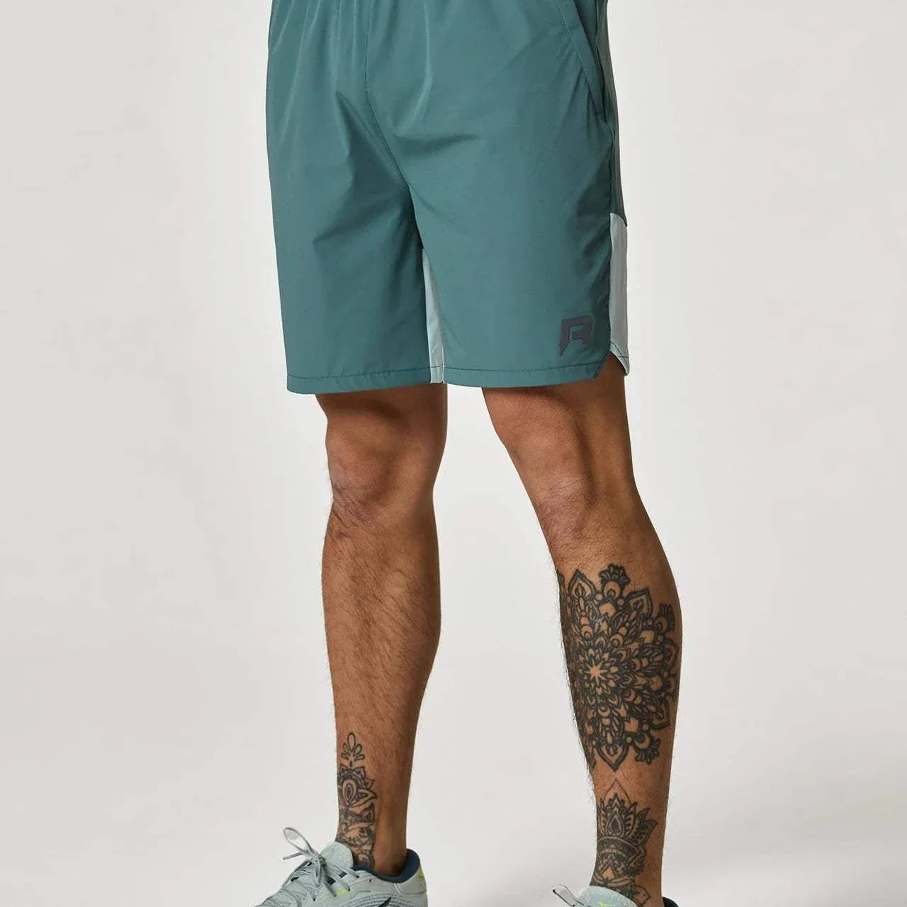 Reprimo Flight Shorts in Forest Green/Mint worn by tattooed model.