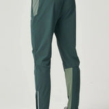 Back view of a person wearing Reprimo Flight Pants in hunter green and botanical with reflective strips and functional pockets