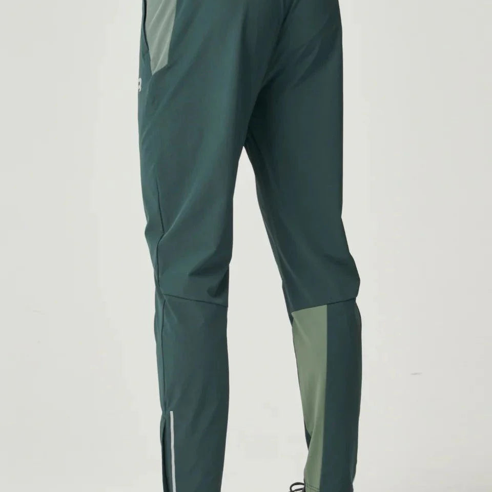 Back view of a person wearing Reprimo Flight Pants in hunter green and botanical with reflective strips and functional pockets