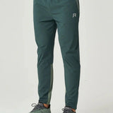 Reprimo Flight Pants in hunter green with reflective strips and secure pockets for athletic performance and comfort