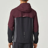 Back view of man wearing burgundy and obsidian Reprimo Impact Windbreaker with hood and dual-fabric construction.