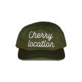 Cherry Location green cap with white embroidered text